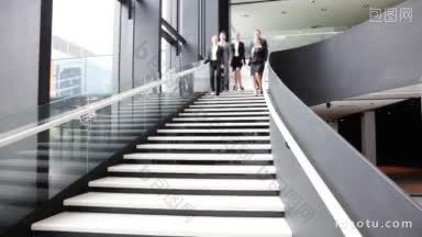 一群商务人士在办公楼的楼梯上走来走去